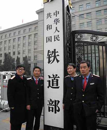 铁道老职工穿定做工作服与铁道部门牌合影